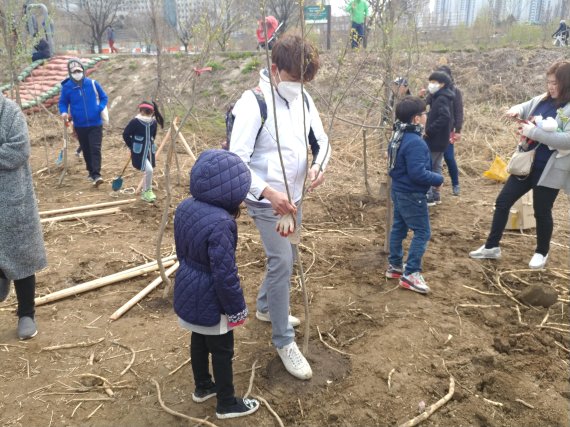 지난 7일 서울 광나루 한강공원에서 열린 '어울림 푸르림' 행사에 참가한 시민들이 나무를 심은 뒤 잘 자라도록 주변을 밟아주고 있다. 사진=김유아 기자