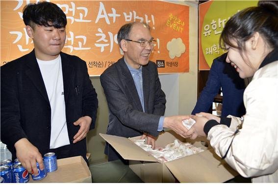 이권현 유한대학교 총장과 학생자치위원장이 학생에게 간식을 나눠주고 있다. 사진제공=유한대학교