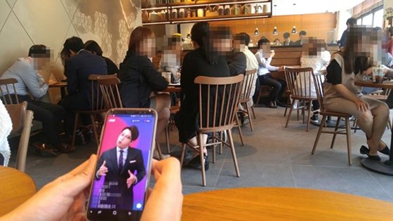 8일 점심시간 서울 여의도의 한 커피전문점에서 직장인들이 실시간 모바일 퀴즈쇼를 풀고 있다. 사진=이환주 기자