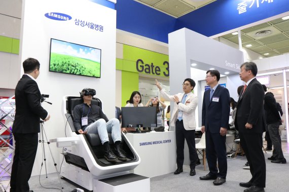 권오정 삼성서울병원 원장(오른쪽 두번째)이 전홍진 교수팀이 개발한 VR-바이오 피드백 시스템의 시연에 대해 설명을 듣고 있다.