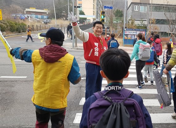 박승희 인천시의원이 선거운동기간에도 불구 매일 아침 인천 서구 가정초등학교 앞 도로에서 교통정리 봉사활동을 해 화제다. 사진은 박 의원이 25년간 학교 앞에서 교통정리를 해오고 있는 모습.