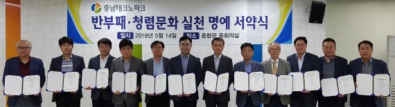 14일 열린 충남테크노파크 반부패·청렴 조직 문화 확산을 위한 서약식에서 윤종언 원장(오른쪽 6번째)을 비롯한 직속 및 직할부서장 12명이 서약서를 들고 기념촬영을 하고 있다.