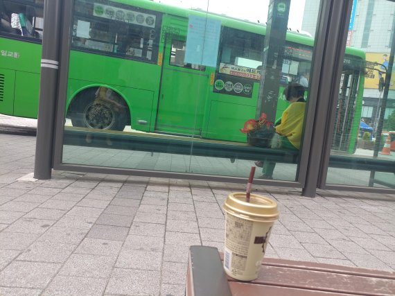 14일 서울의 한 버스정류장에 뒤쪽 벤치에 버려진 음료컵/사진=김유아 기자