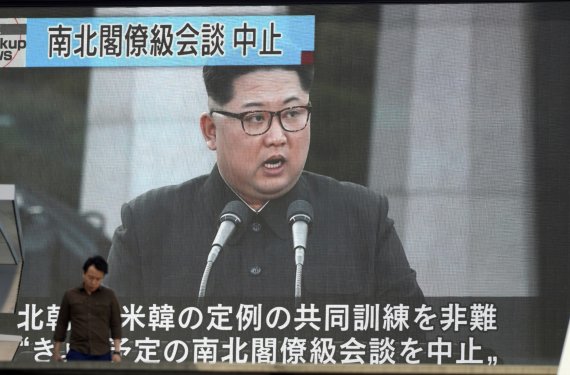 16일 일본 도쿄에서 한 시민이 북한의 남북고위급회담 취소 소식을 전하는 대형 TV 앞을 지나고 있다. AP연합뉴스