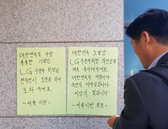 한 시민이 지난 21일 서울 대학로 서울대학교병원 장례식장에 마련된 구본무 LG그룹 회장의 빈소를 찾아 'LG 의인상'을 유지해달라는 문구를 써붙이고 있다. 사진=권승현 기자