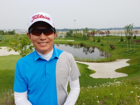파3홀 코스를 배경으로 포즈를 취하고 있는 강욱순.