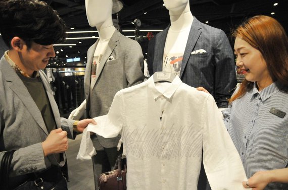 롯데백화점 대구점을 찾은 남성 고객(왼쪽)이 '큐리오시티 오브 레노마' 매장(6층)에서 린넨셔츠를 살펴보고 있다.