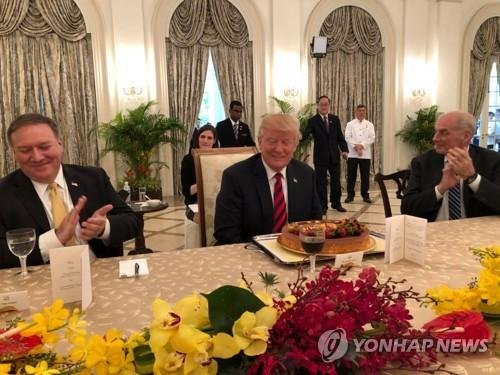 도널드 트럼프 미국 대통령(가운데)이 11일 싱가포르 대통령궁인 이스타나궁에서 리셴룽 싱가포르 총리와 오찬을 겸한 확대 정상회담에서 생일케이크를 받고 미소짓고 있다. 트럼프 대통령의 생일은 오는 14일이다.연합뉴스