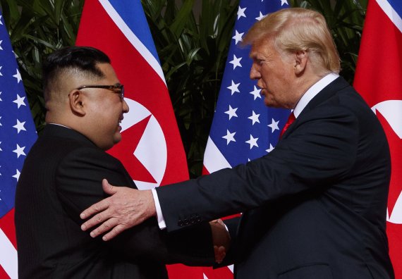 도널드 트럼프 미국 대통령(오른쪽)이 지난 12일 싱가포르에서 김정은 북한 국무위원장과 악수를 나누고 있다.AP연합뉴스
