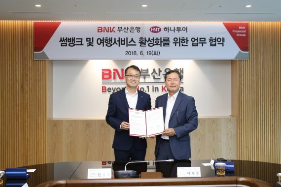 BNK부산은행은 19일 부산은행 본점에서 하나투어와 ‘썸뱅크-여행서비스강화’를 위한 업무협약을 체결했다고 밝혔다. 이날 협약식에 참석한 한정욱 BNK부산은행 디지털금융본부장(왼쪽), 이재봉 하나투어 영남사업본부장이 기념촬영을 하고 있다.