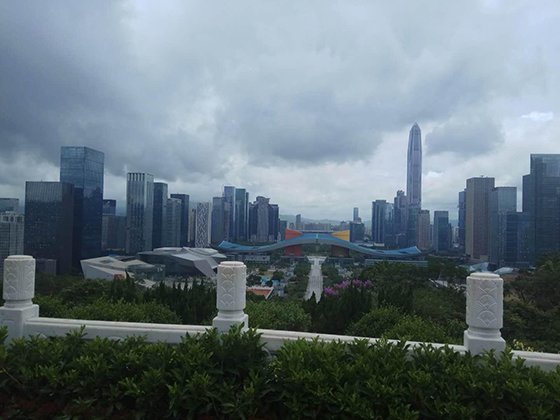 덩샤오핑 동상이 세워진 중국 광둥성 선전 롄화산 공원 정상에서 앞 방향으로 선전시청 건물이 날개를 편 듯한 외관을 드러내고 있다. 멀리 보이는 섬은 중국 초기 개혁개방의 선호 모델이던 홍콩이다.
