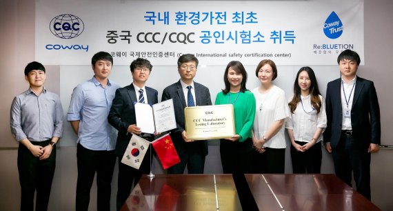 코웨이 안전인증센터(TQA) 정선용 센터장(왼쪽 네 번째)과 백미라 CCIC코리아 부사장(왼쪽 다섯 번째)을 포함한 임직원들이 지난 20일 현판 전달식을 진행하며 기념 사진을 촬영하고 있다.