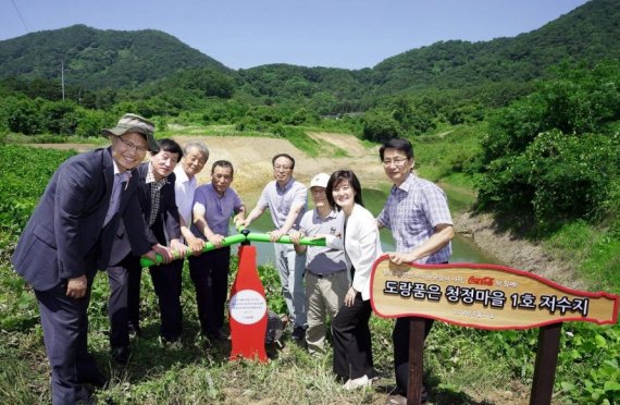 21일 경남 김해시 진례면 시례마을에서 박형재 한국 코카콜라 상무(오른쪽 두번째), 윤세웅 WWF-Korea 대표(오른쪽 세번째), 신진수 낙동강유역환경청장(왼쪽 첫번째), 김판돌 김해시 환경위생국장(왼쪽 두번째) 및 상촌∙하촌∙신기마을의 관계자들이 상촌마을 ‘도랑품은 청정 마을 1호 저수지’ 준설 완공을 축하하며 저수지의 수문을 개방하는 통수식을 진행하고 있다.