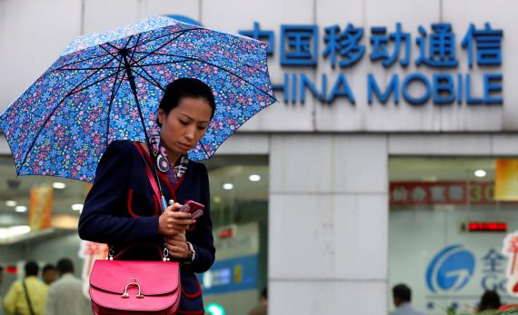 FILE PHOTO: A woman uses her mobile phone in front of a China Mobile office in downtown Shanghai October 22, 2012. REUTERS/Aly Song/File Photo <All rights reserved by Yonhap News Agency>