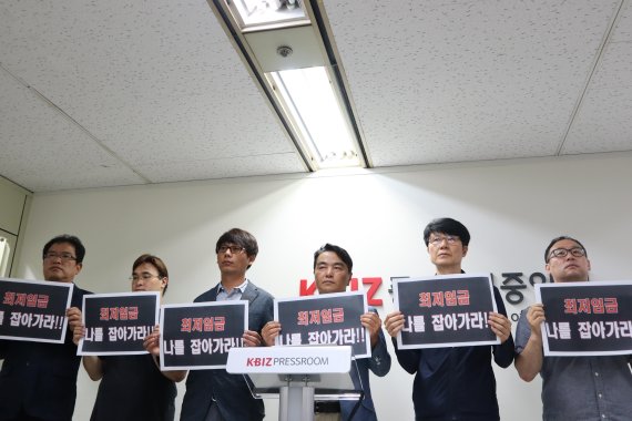 전국편의점가맹점협회 관계자들이 12일 서울 여의도 중소기업중앙회에서 열린 긴급 기자회견에서, '최저임금, 나를 잡아가라'는 피켓 시위를 하고 있다.