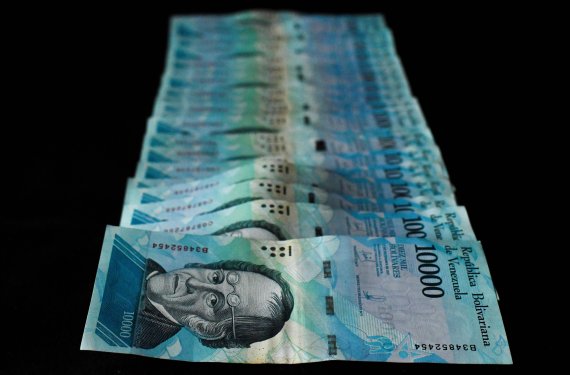 Picture of 10.000 bolivar-bill taken in Caracas on July 26, 2018. Venezuelan President Nicolas Maduro on July 25 announced the removal of five zeroes from the country's currency -- two more than originally planned -- amid hyperinflation the IMF said could reach one million percent this year. / AFP P