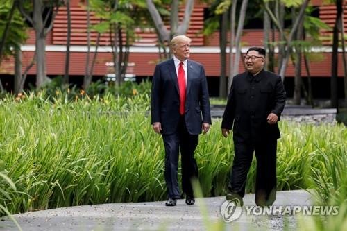 U.S. President Donald Trump and North Korea's leader Kim Jong Un walk together before their working lunch during their summit at the Capella Hotel on the resort island of Sentosa, Singapore, June 12, 2018.로이터연합뉴스