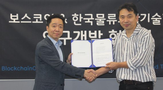 최예준 블록체인OS 대표(오른쪽)와 한국물류과학기술학회 정호상 사업이사가 물류 및 유통 분야 블록체인 활용방안 관련 연구협약을 체결하고 기념 촬영을 하고 있다.
