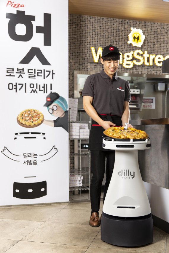 배달의민족을 운영하는 우아한형제들이 한국피자헛과 손잡고 서울 피자헛 목동중앙점에서 서빙 로봇 '딜리 플레이트'를 선보였다.