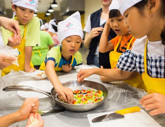 행복얼라이언스 건강플러스 캠프에 참가한 아이들이 직접 요리를 만들며 식재료와 친해지는 시간을 갖고 있다.