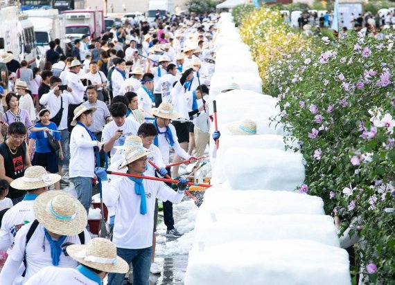 지난 11일 서울 광화문 광장에서 열린 '2018 한여름밤의 눈조각전'에 참여한 크라운해태제과 임직원 300여명이 눈조각을 하고 있다.