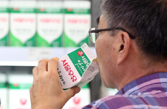 한 소비자가 서울의 한 대형마트에서 서울우유를 마시고 있다. 연합뉴스