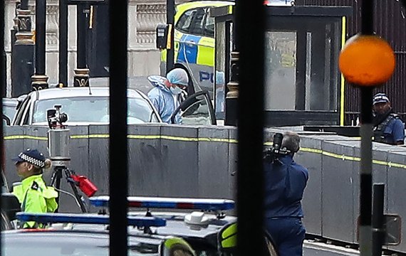 영국 경찰들이 14일(현지시간) 런던 의회 인근에서 콘크리트 보호벽을 들이받고 멈춘 용의차량을 조사하고 있다.AFP연합뉴스