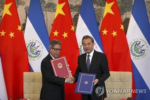El Salvador's Foreign Minister Carlos Castaneda, left, and China's Foreign Minister Wang Yi shake hands at a signing ceremony to mark the establishment of diplomatic relations between the two countries at the Diaoyutai State Guesthouse in Beijing Tuesday, Aug. 21, 2018. Taiwan broke off diplomatic t
