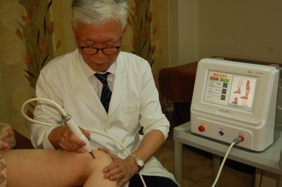 심영기 연세에스의원 원장이 전기자극통증치료기를 이용한 전기충전요법으로 무릎관절염 환자를 치료하고 있다.