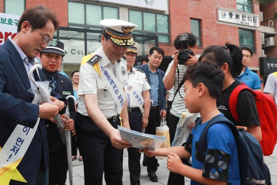 이주민 서울지방경찰청장(왼쪽에서 세번째)이 30일 오전 종로구 재동초등학교에서 학생에게 교통안전 관련 안내물을 나눠주고 있다.