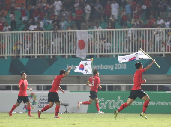 1일 오후 열린 2018 아시안게임 남자축구 결승전에서 일본을 2-1로 꺾은 한국 대표팀 선수들이 경기 종료 휘슬이 울리자 태극기를 들고 그라운드를 달리고 있다. 사진=연합뉴스