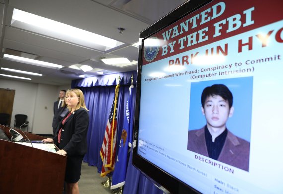 트레이시 윌키슨 미국 법무부 차관보가 6일(현지시간) 미국 로스앤젤레스에서 북한 국적의 해커 박진혁(사진 속 스크린상의 인물)을 기소했다고 발표하고 있다. AFP연합뉴스
