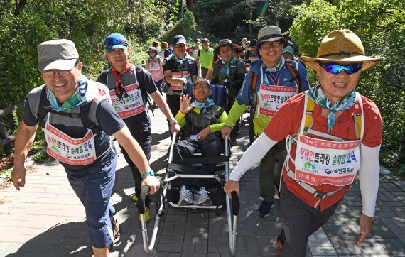 한국트레킹연맹은 지난 8일 세 명의 중증 지체장애인과 함께 북한산 우이령길을 올랐다. 특수제작된 휠체어에 앉은 참가자가 봉사자들과 산행을 하고 있다. 사진=김범석 기자