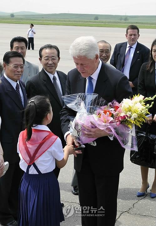 ▲ 2009년 8월 빌 클린턴 전 미국 대통령이 북한 평양비행장에 도착해 화동으로부터 꽃다발을 받고 있는 모습.연합뉴스