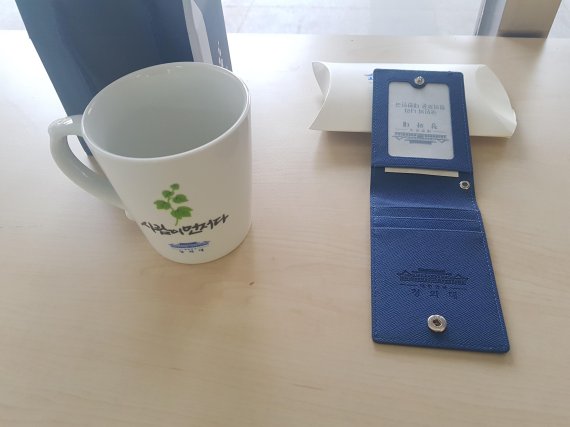 청와대는 관람객들에게 기념품을 선물하고 있다. 성인에게는 머그컵(왼쪽)을, 어린이들에게는 목걸이형 카드지갑을 주고 있다. /사진=이태희 기자