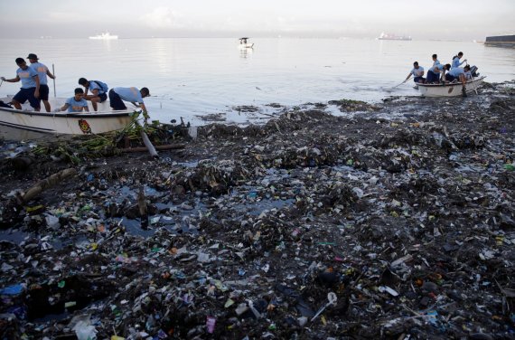 필리핀 마닐라에서 경찰들이 22일 '세계 해안청소의 날'을 맞아 해안에 밀려온 쓰레기들을 치우고 있다.로이터연합뉴스