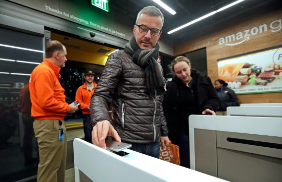 A customer scans his Amazon Go cellphone app at the entrance as he heads into an Amazon Go store, Monday, Jan. 22, 2018, in Seattle. The store, which opened to the public on Monday, allows shoppers to scan their smartphone with the Amazon Go app at a turnstile, pick out the items they want and leave