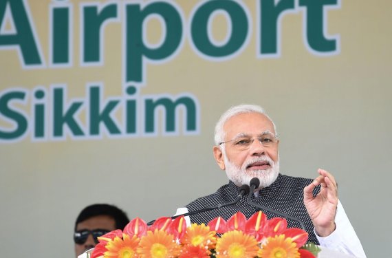 This handout photo released by India's Press Information Bureau and taken on September 24, 2018, shows Indian Prime Minister Narendra Modi (R) addressing a gathering at the inauguration of the Pakyong Airport in Gangtok. (Photo by Handout / PIB / AFP) / RESTRICTED TO EDITORIAL USE - MANDATORY CREDIT