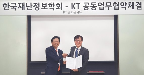 김준근 KT 기가 IoT사업단장 전무(오른쪽)와 이래철 한국재난정보학회 회장이 업무협약을 마치고 기념촬영을 하고 있다.