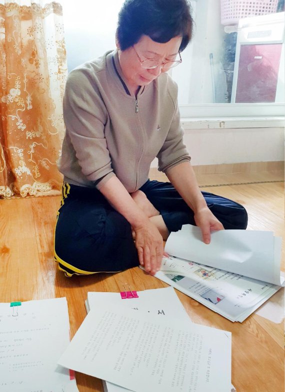 탈북민 손명화씨가 보훈처로부터 받은 답변 자료들을 살펴보고 있다./사진=이진석 기자