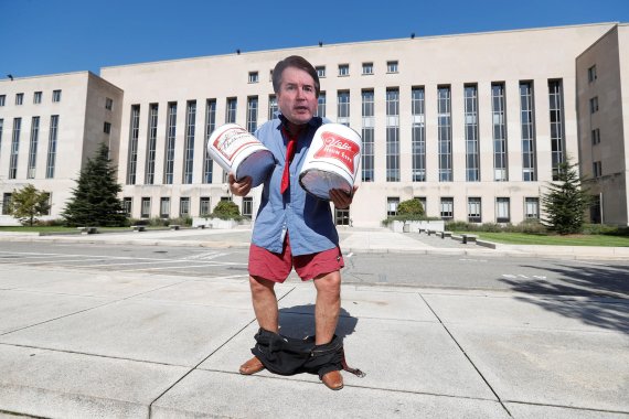 An activist costumed as U.S. Supreme Court nominee Brett Kavanaugh holds prop beer cans as activists gather for a protest march and rally in opposition to Kavanaugh's nomination outside U.S. District Court in Washington, U.S., October 4, 2018. REUTERS/Kevin Lamarque<All rights reserved by Yonhap New
