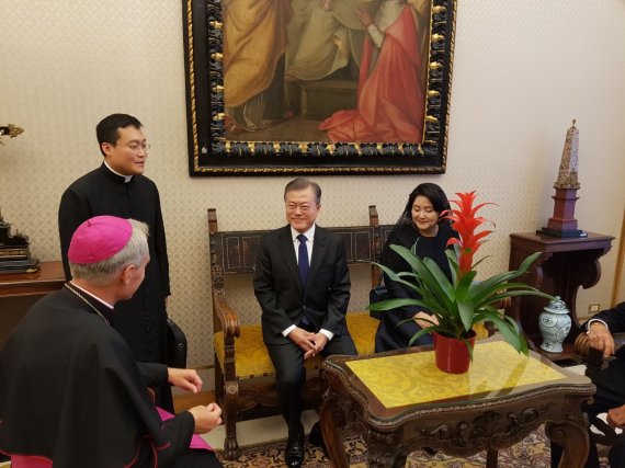 청와대가 문 대통령 유럽 순방중 수행원들이 휴대전화로 찍은 'B컷'을 공개했다. 사진은 프란치스코 교황 알현을 위해 대기중인 문재인 대통령과 김정숙 여사가 교황청 의전관과 대화하고 있는 모습. 청와대 제공