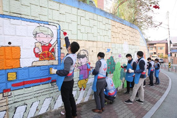 한국도로공사 직원들이 지난 5일 김천 서부초등학교 담벼락에 벽화를 그리고 있다.