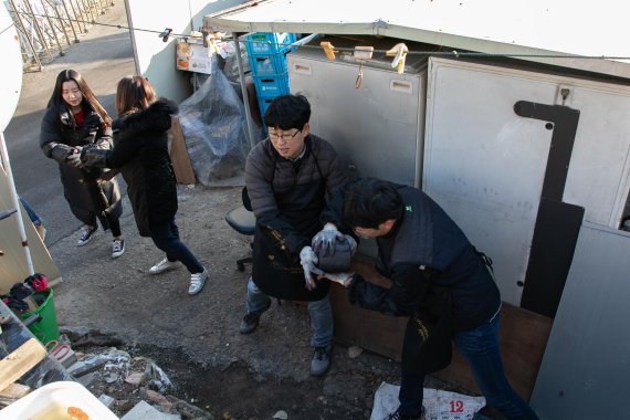 진에어가 지난 22일 경기도 광명시 소하동에서 사랑의 연탄 나눔 봉사활동을 실시했다. 진에어 임직원들이 연탄을 옮기고 있다. /사진=fnDB