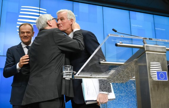 TOPSHOT - President of the European Commission Jean-Claude Juncker (C) kisses EU chief Brexit negotiator Michel Barnier (R) next to European Council President Donald Tusk (L) at the end of a press conference following a special meeting of the European Council to endorse the draft Brexit withdrawal a