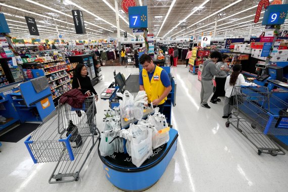 FILE- In this Friday, Nov. 9, 2018, file photo Walmart associate Luis Gutierrez, center, checks out a customer at a Walmart Supercenter in Houston. (AP Photo/David J. Phillip, File) <All rights reserved by Yonhap News Agency>
