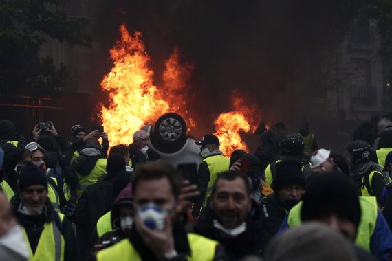 지난 1일(현지시간) 프랑스 파리 개선문 인근에서 노란조끼 시위대와 경찰이 충돌하는 가운데 차량이 불타고 있다.EPA연합뉴스
