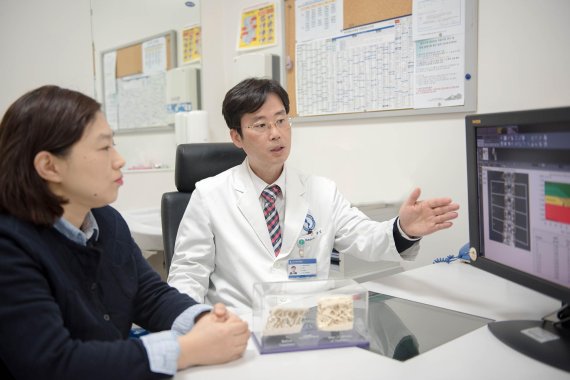 정윤석 아주대학교병원 내분비내과 교수(오른쪽)가 골다공증 환자에게 'P1NP 테스트' 검사 결과를 설명하고 있다.