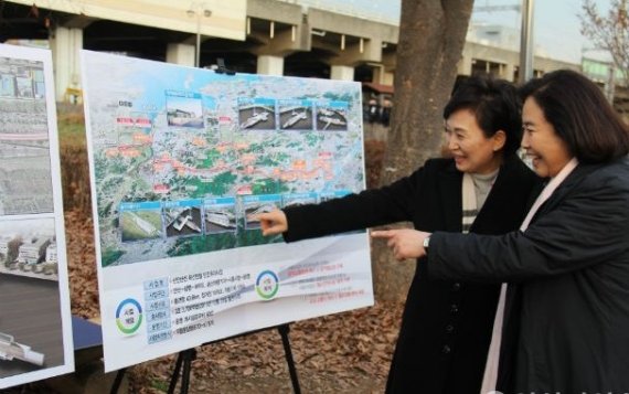 박순자 국회 국토위원장(오른쪽)과 김현미 국토부장관이 5일 안산 중앙역사 광장에서 신안산선의 노선도를 보면서 얘기를 나누고 있다.