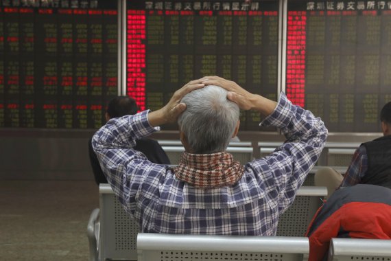 중국 베이징에서 한 투자자가 6일 증시 전광판을 보며 머리를 싸매고 있다. 이날 상하이종합지수는 전장 대비 44.62포인트(1.68%) 하락한 2605.18에 마감됐다. AP연합뉴스